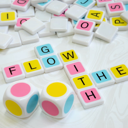 Candygrams “the colorful crossword game” is the perfect combination of skill, strategy, and luck. large colorful dice along with a colorful letter tile crossword spelling ‘go with the flow’ on a swirling white background