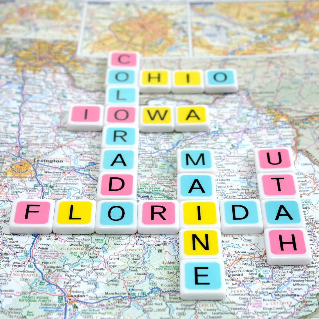 Throw out the rules and add your own twist to the Candygrams board game. colorful letter tiles spell out the names of US states on a map of America background