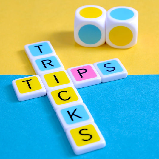 Learning a few tips and tricks can help make a better Candygrams player. large colorful dice along with a colorful letter tile crossword spelling ‘tips tricks’ on a yellow and blue background