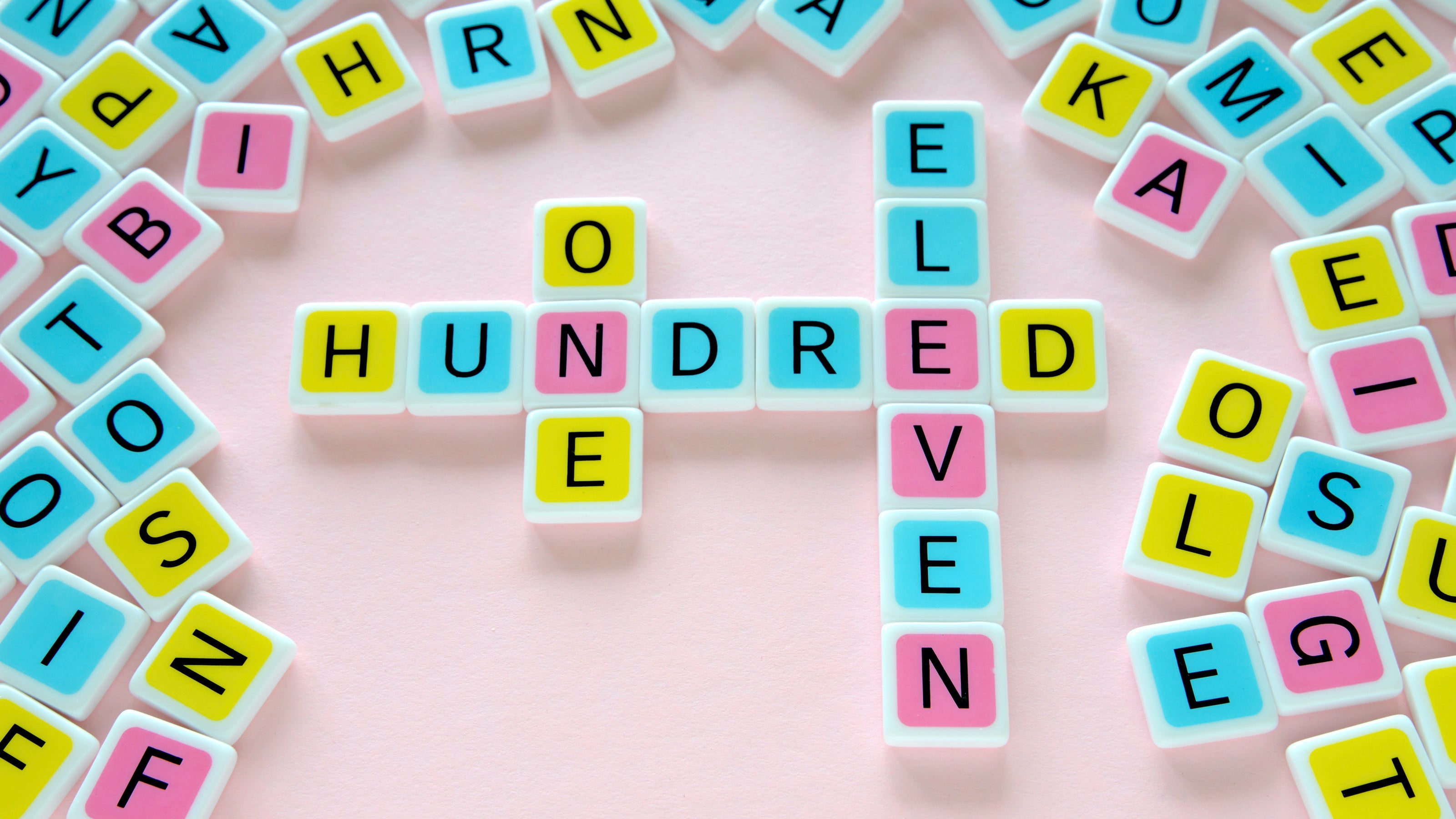 candygrams board game 111 one hundred eleven colorful letter tiles made with pure acrylic and printed with 100% vegetable inks on a pink background