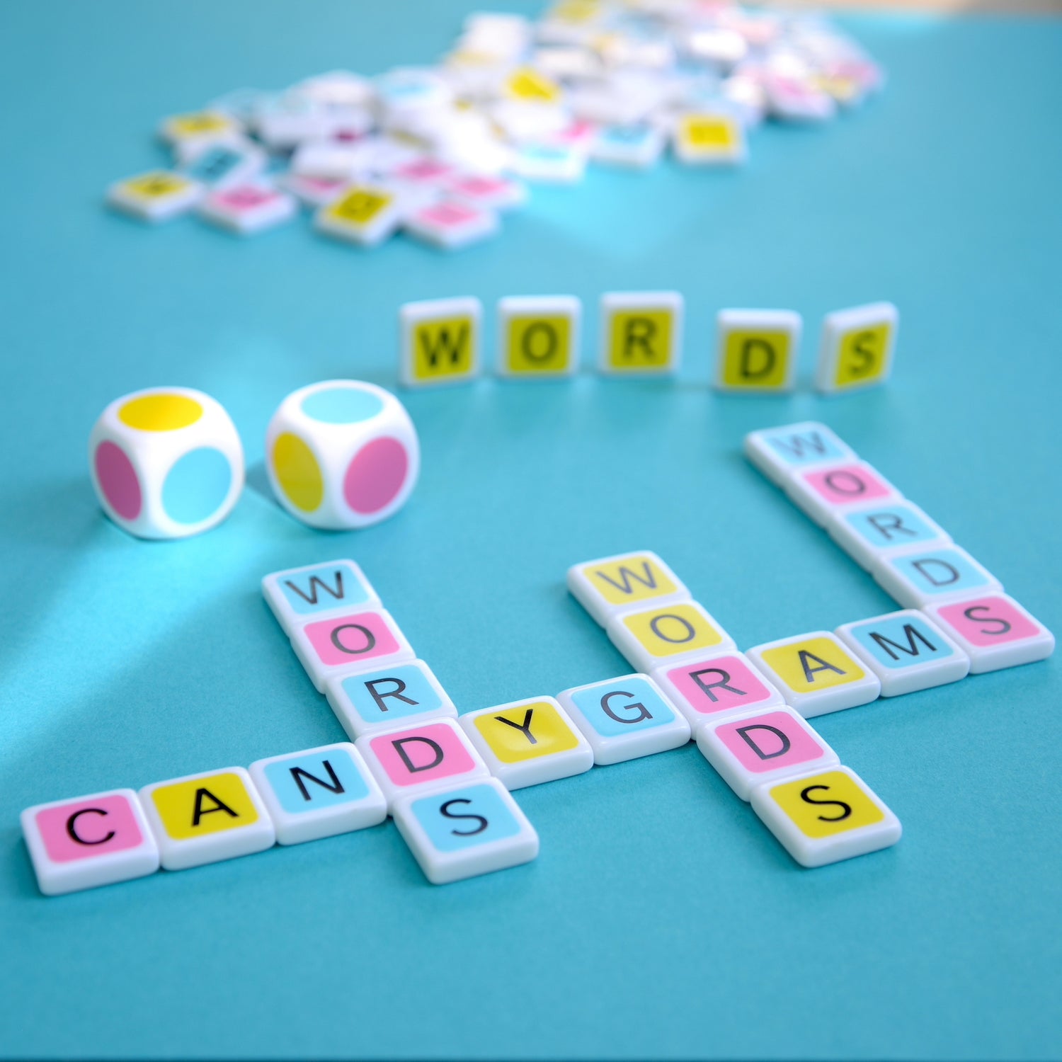 Candygrams is a word game that’s all about words. Win the board game by building great words, not by tallying up tiny numbers. ‘words' crossword made with colorful letter tiles and pastel colored dice on a blue background
