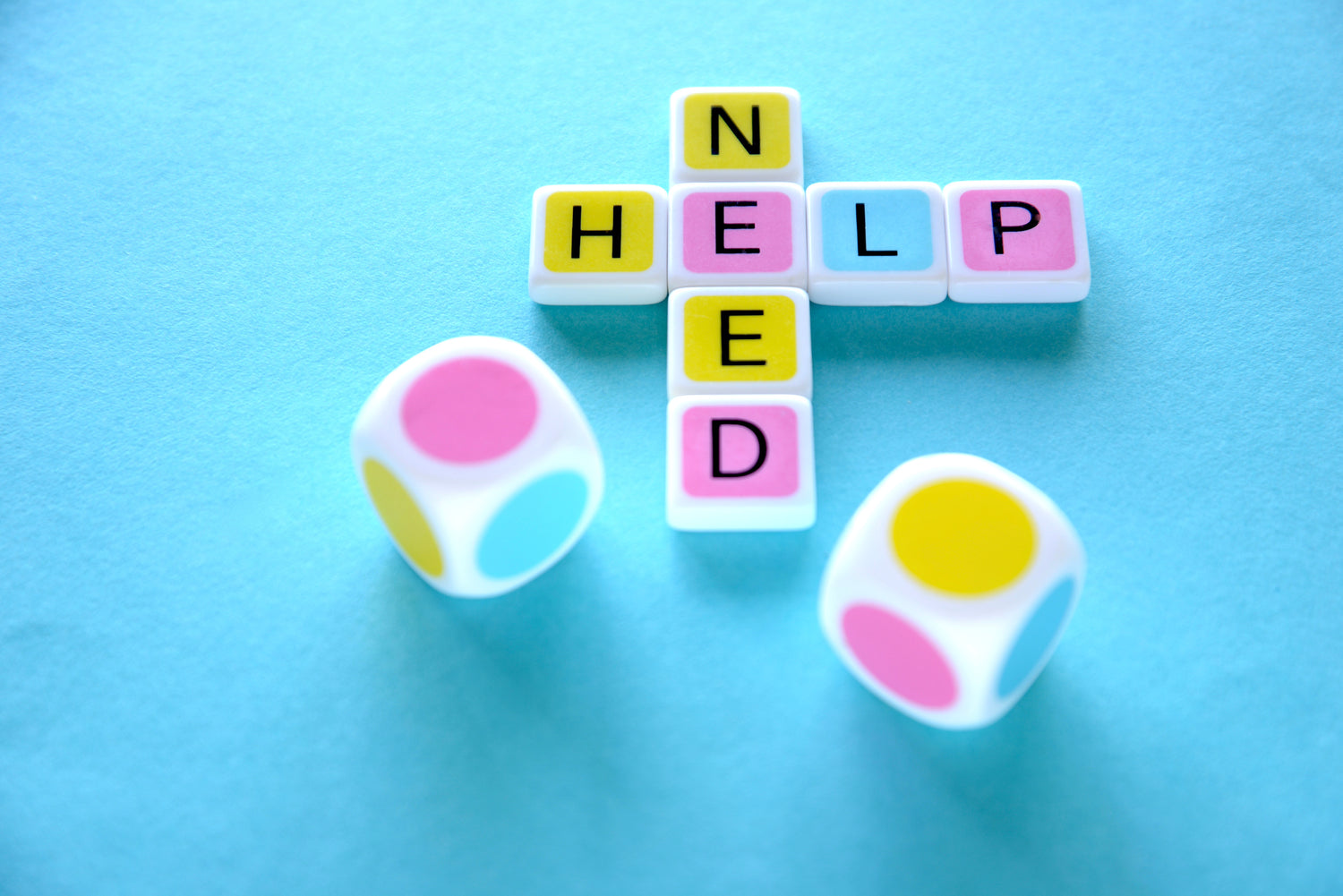candygrams word game ‘need help' crossword made with colorful letter tiles and pastel colored dice over a blue background